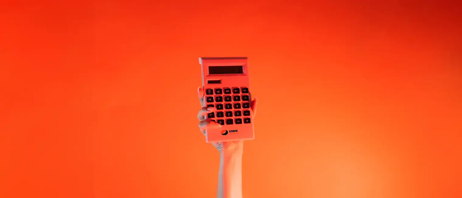 Ein Arm ist vor orangenem Hintergrund senkrecht nach oben gestreckt und in der Hand wird ein Taschenrechner gehalten.