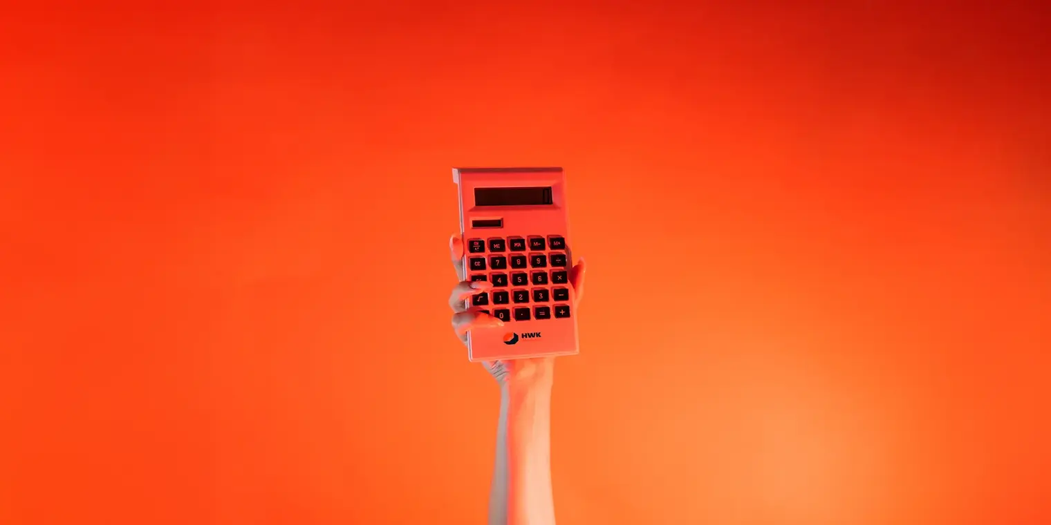Ein Arm ist vor orangenem Hintergrund senkrecht nach oben gestreckt und in der Hand wird ein Taschenrechner gehalten.