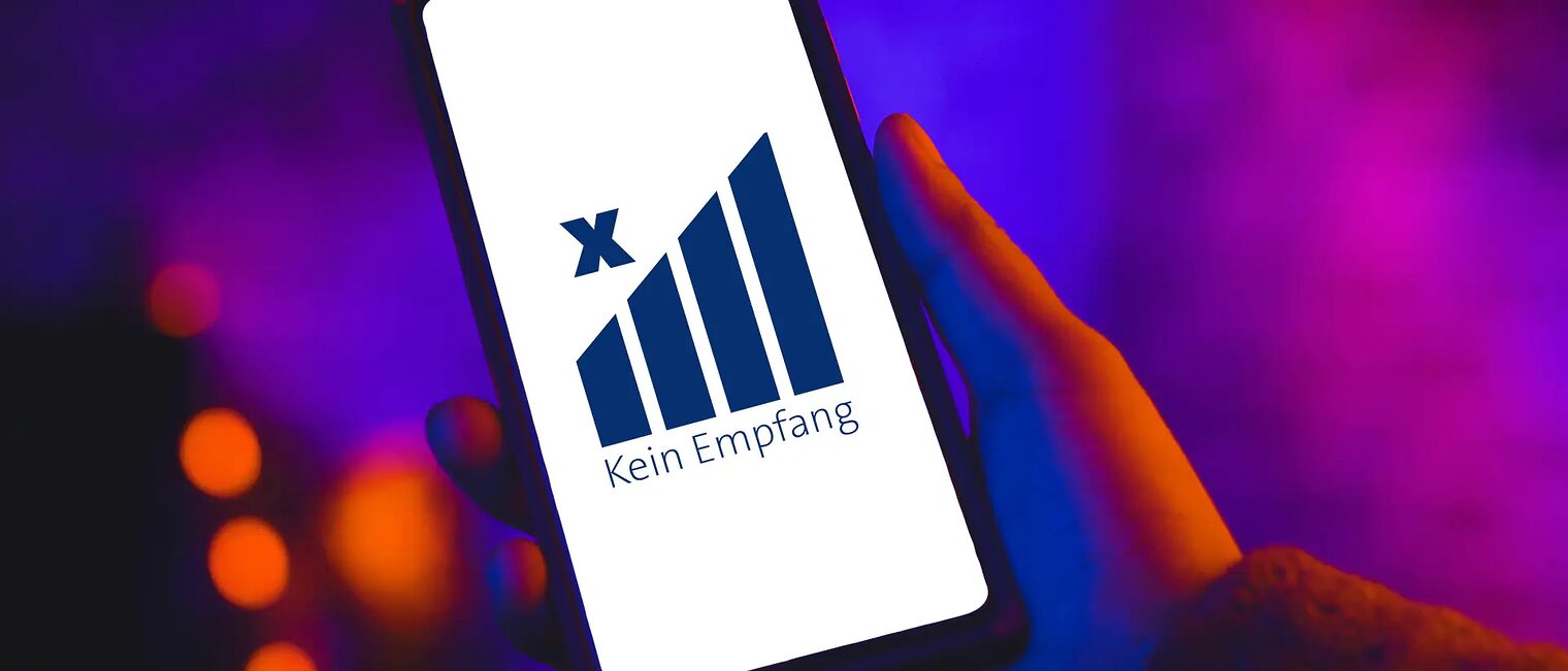 Eine Hand hält ein Smartphone auf dessen Display groß angezeigt wird, dass es keinen Empfang hat.