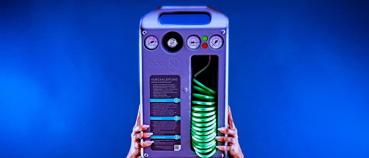 Zwei Hände halten ein Gefäßfüllsystem für Membranausdehnungsgefäße mit Mehrweg-Druckgasflaschen in die Höhe.